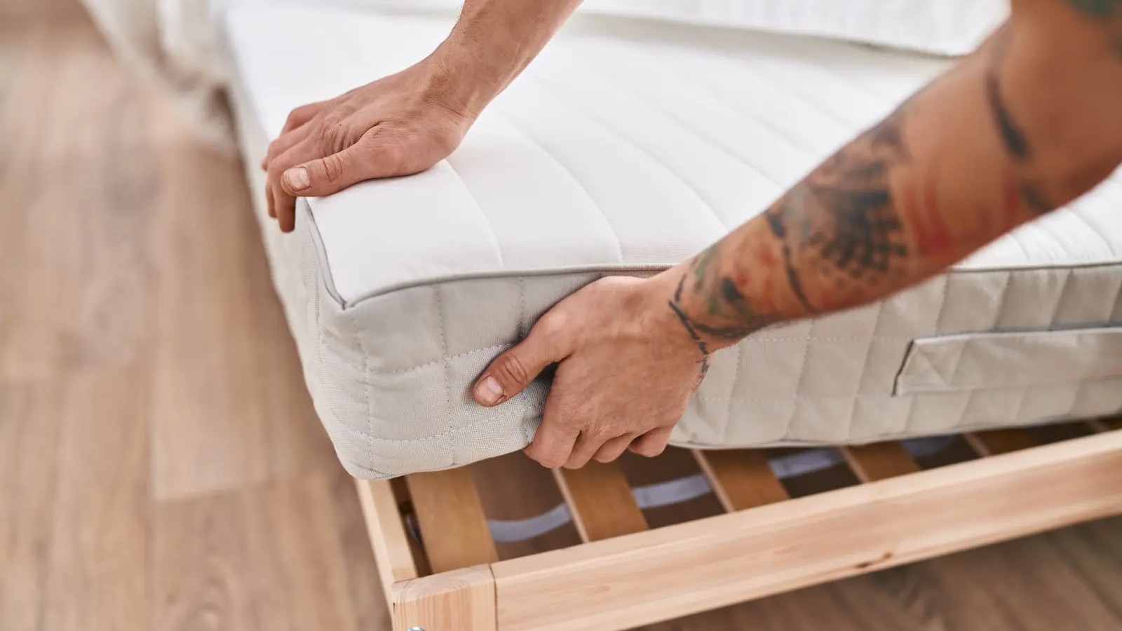 мужчина держит матрас